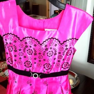 Girls party dress fuchsia and black floral print. Button closure with sash tie.